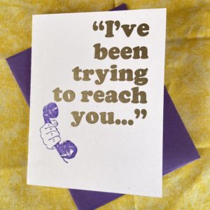 Image of a card. The card reads “I’ve been trying to reach you…” in large gold letters, and in the lower left corner is an image of a hand holding a mid-twentieth century telephone handset.